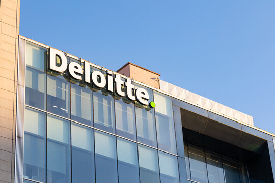 2026-07-02 Lisboa, Portugal - Deloitte logo displayed on the facade of a modern office building with glass architecture and blue sky background. Photograph taken in an urban business district