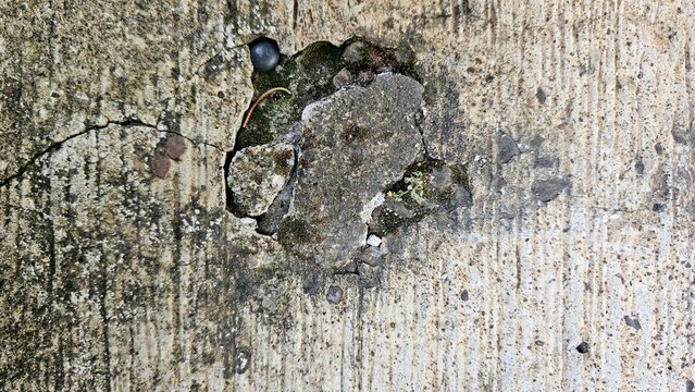 Old, damaged, cracked, and dirty cement floor.