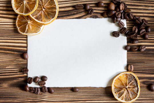 Blank Paper Sheet with Coffee Beans and Dried Citrus Slices on Rustic Wooden Background
