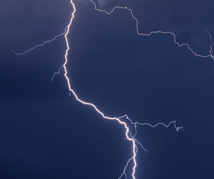 Bright lightning bolt in a blue cloudy sky