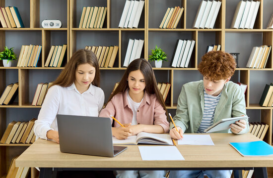 Students teenagers team study with laptop. In the library they work on notes, applying learning and teamwork to plan a project and finish homework. Clear study teamwork education concept.