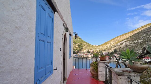 White building with blue shutters in Kastellorizo, Greece