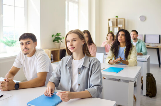 Students in a classroom listening during lecture. Attentive college and university learners take notes to study, focusing on a teacher led lesson. Concept shows higher education learning.