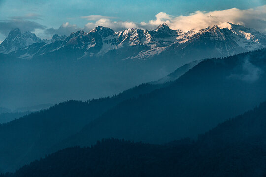 Dayara Bugyal Uttarakhand India. Bandarpoonch, Draupadi Ka Danda and other Gangotri Glacial Peaks. Snowy mountain peaks above layered blue hills