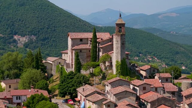 Greccio Rieti Lazio Italy 4K Drone. Aerial flight over rooftops and bell tower to green valley with historic monastery in rock. Most beautiful villages cinematic b roll video asset