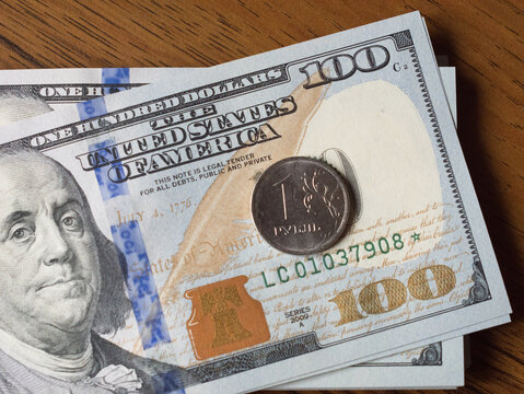 Close-Up of U.S. Hundred Dollar Bill and Russian One Ruble Coin