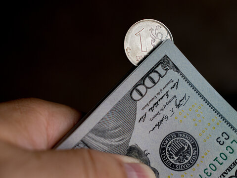Ruble Coin and Dollar Bills Stacked Together