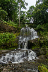 Beautiful tropical waterfall cascading down mossy rocks in a dense green forest, La Palmita waterfall in La Azulita, Merida, Venezuela. © javier