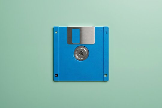 Blue floppy disk on a soft green background with technology computer magnetic background software hardware electronic information computing obsolete portable diskette innovation platform