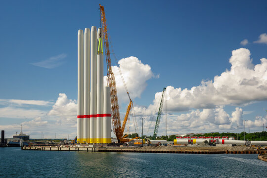 Giant Crawler Crane Assembling Wind Turbine Tower Sections at Port Harbor, Sustainable Offshore Renewable Energy Construction and Logistics