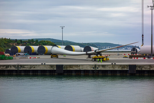 Huge Wind Turbine Blade on Specialized Transport Vehicle at Industrial Port, Offshore Renewable Energy Logistics and Infrastructure Development