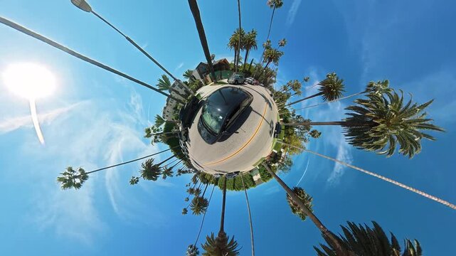 Tiny planet view of a palm lined street in Beverly Hills Los Angeles, Creative spherical driving scene with cars homes and vivid California sunshine