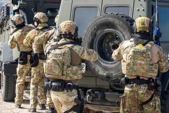 Armed Special Forces Soldiers in Camouflage Tactical Gear Storming Armored Vehicle During Military Training Exercise or Combat Operation