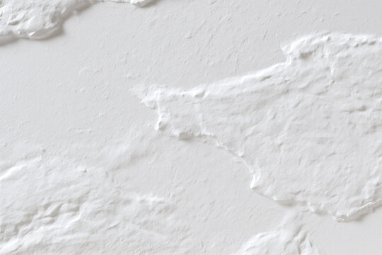 Textured white plaster wall with torn paper edges and subtle shadows, minimal abstract surface detail conveying rough handmade texture and soft light