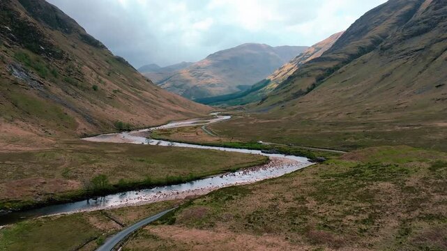 Scotland, Glen Etive,  drone flight along river and winding road through Scottish Highlands valley