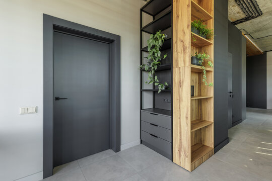 Modern Interior Hallway with Dark Grey Door and Wooden Shelving