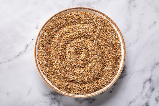 Buckwheat groats prodel in ceramic plate on marble table top view healthy food