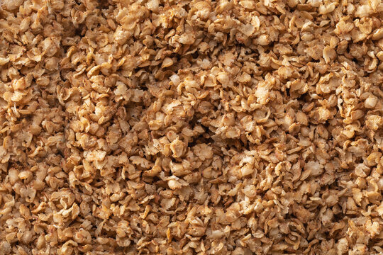Buckwheat flakes background golden brown cereal grain texture top view healthy food