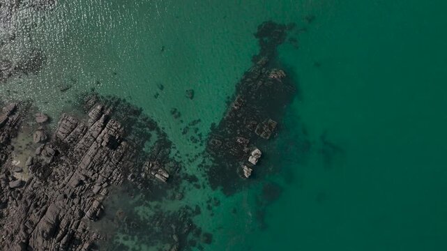 Aerial top-down view of rocks, sand and clear water at Chausey, France