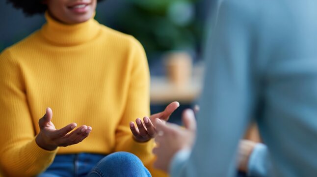 Woman in yellow turtleneck sweater having a conversation and gesturing while talking