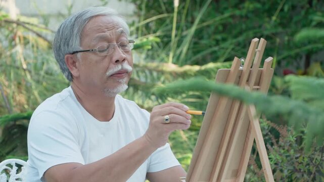 Artist's Contemplation in the Garden: A mature artist, immersed in his creative process, delicately paints on a canvas while enjoying the serene atmosphere of a garden.