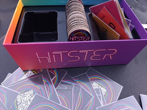 Hitster - Jogo de cartas e m&uacute;sica. O objetivo &eacute; simples: voc&ecirc; n&atilde;o precisa ser um especialista em m&uacute;sica, basta reconhecer os sucessos e organiz&aacute;-los em uma linha do tempo cronol&oacute;gica.
