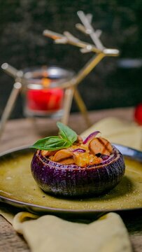 Roasted purple onion bowl filled with caramelized slices and fresh basil on a rustic plate, warm moody lighting suggests cozy gourmet dining