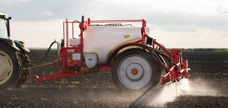 Agricultural field sprayer applying herbicide on cultivated farmland