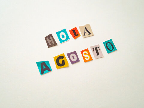 Hello August message in Spanish made from colorful paper cutout letters on white background