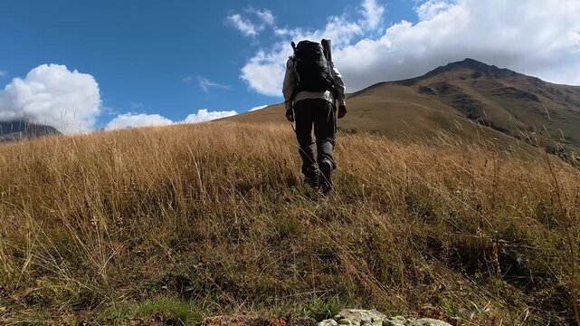 4K Solo Hiker Walking Through Golden Grass Meadow Toward Mountain Peak, Georgia