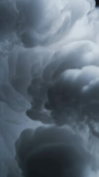 Vertical video: Entering top gray plume cascading down in tank following flow against dark backdrop
