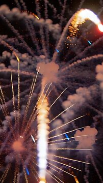 Vertical video: Launching shells producing radial bursts and smoke in night sky, with sparks