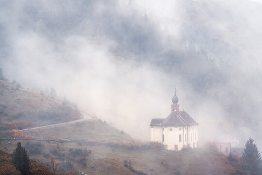 View of Maria-Hilf Chapel in fog near Andermatt in Switzerland.