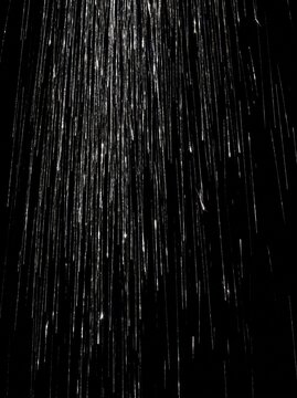 Silver glitter rain overlay falling on black vertical background luminous streak curtain