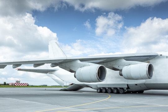 Unloading a white big heavy transport aircraft. The rear cargo compartment is open