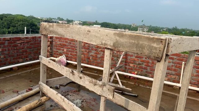 Rooftop Construction Site with Wooden Scaffold Stand and Brick Parapet Wall
