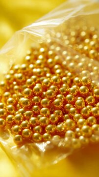 Packaged golden beads with a shiny surface, ready for jewelry making or craft projects.