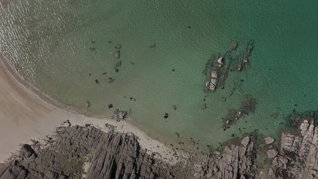 Aerial top-down view of rocks, sand and clear water at Chausey, France