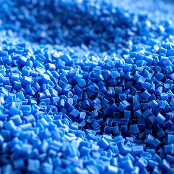 A close-up view of a pile of small, vibrant blue plastic pellets