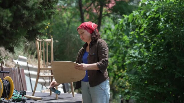 craftswoman refurbishing an old wooden chair, furniture repair, restoration and woodworking