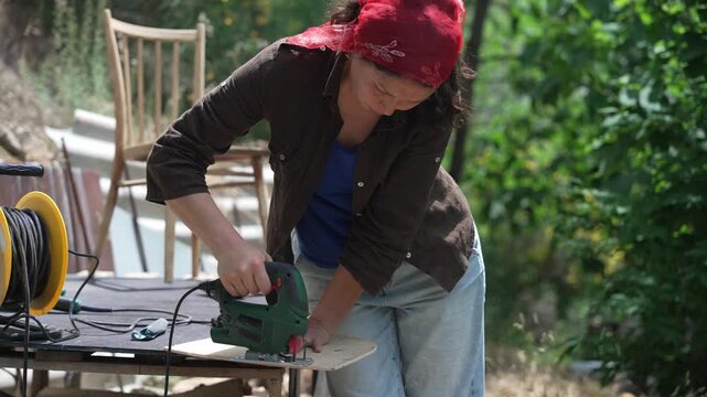 Woman renovating an old wooden chair, sustainable furniture restoration and upcycling