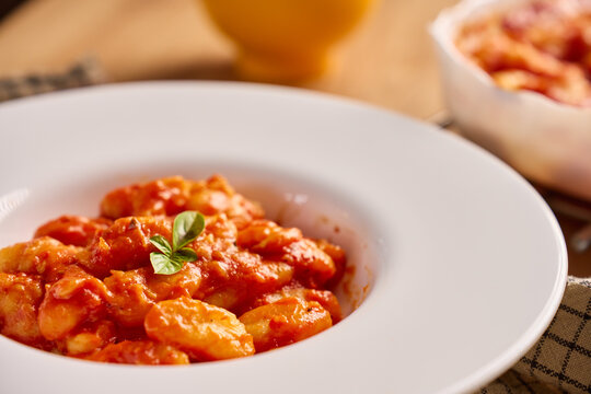 Gnocchi in tomato sauce served with fresh basil on plate
