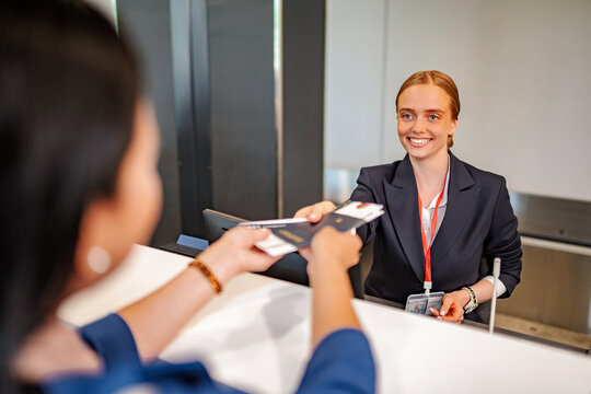 Airline staff helping traveler with check-in at airport counter