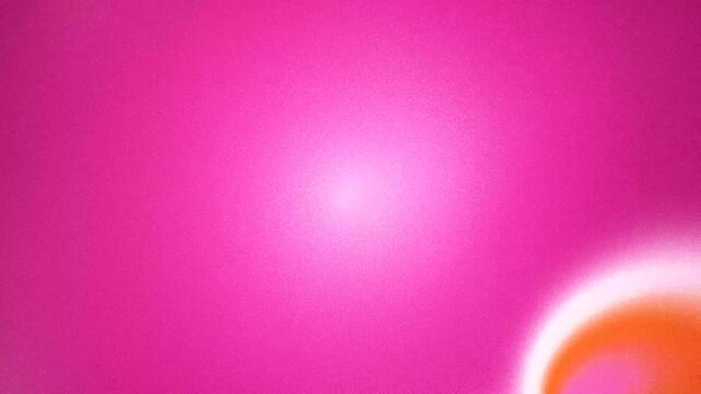 Abstract fuchsia and orange gradient background with soft light and grainy texture.