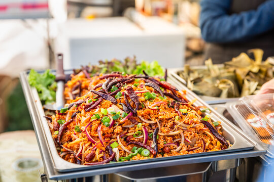 Spicy Thai rice salad with dried chilies and fresh herbs served at a street food stall