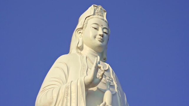Majestic long shot of the iconic Lady Buddha statue towering against a clear blue sky in Da Nang, Vietnam, symbolizing peace and spirituality.