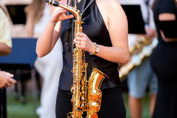 Obraz premium Young musician playing saxophone during lively street concert in spain