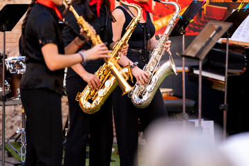 Obraz premium Young spanish musicians performing an outdoor concert with saxophones