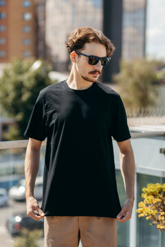 Man wearing black blank t-shirt with space for your logo or design. Mock up	
