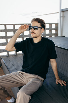 Man wearing black blank t-shirt with space for your logo or design. Mock up	
